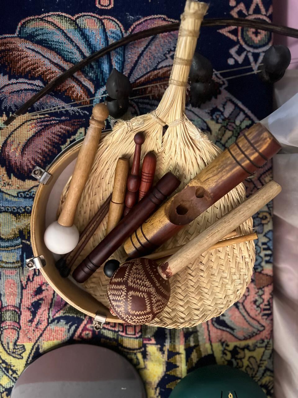 Instrumentos sonoros y pindas herbales sobre una bandeja tejida