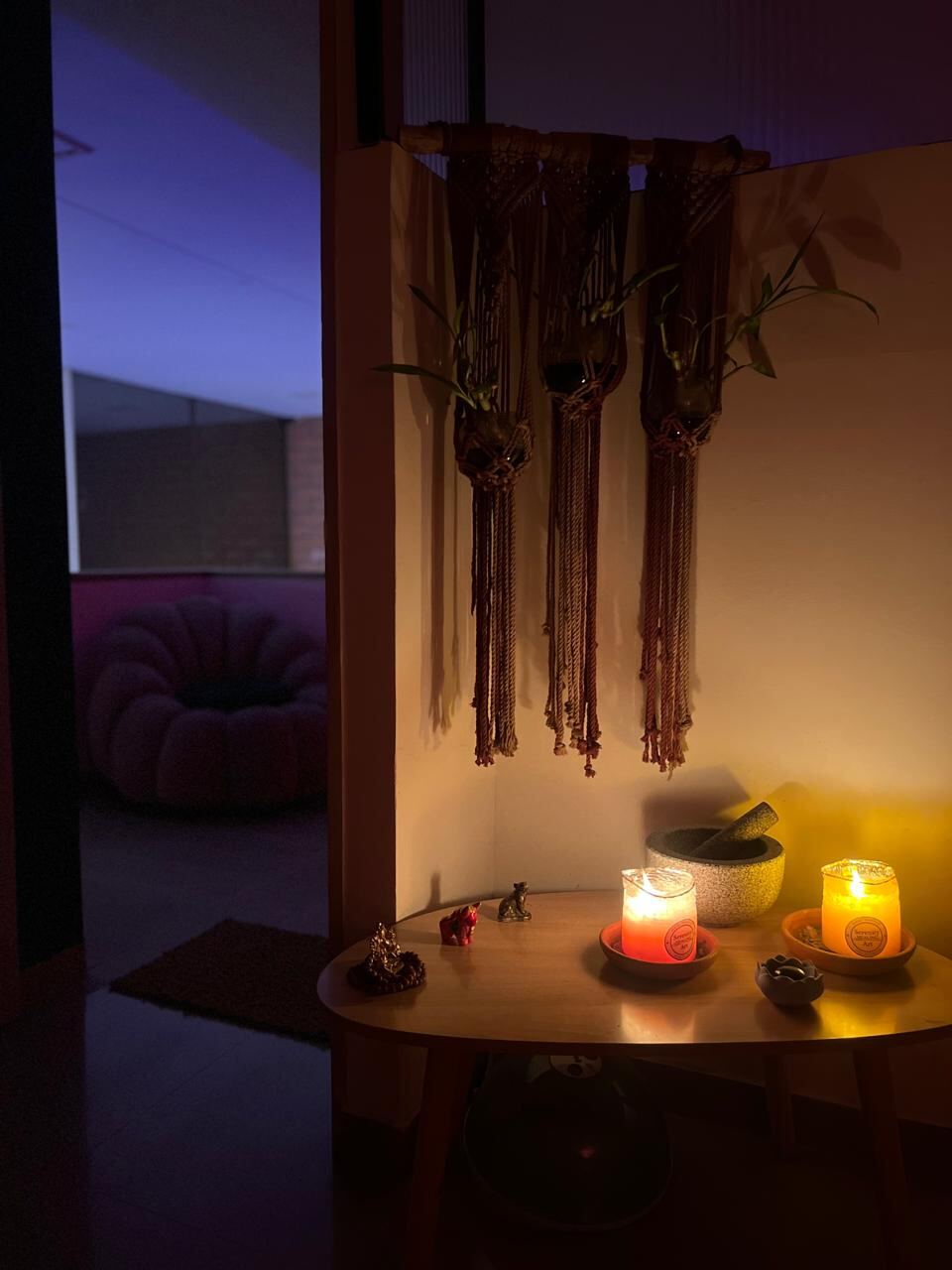 Rincón con velas encendidas y tejidos colgantes